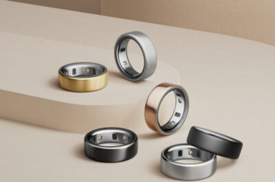 Ein stilvoll arrangiertes Set aus sechs modernen Smart-Ringen in verschiedenen Metallfarben – darunter Gold, Schwarz, Silber, Roségold und gebürstetes Grau – auf einer minimalistischen beigen Stufenplattform. Die Ringe sind mit eingebauten Sensoren auf der Innenseite ausgestattet und reflektieren einen eleganten, technologischen Look. Die Komposition betont die luxuriöse Verarbeitung und die Vielseitigkeit der Smart-Ringe als modische Wearables.